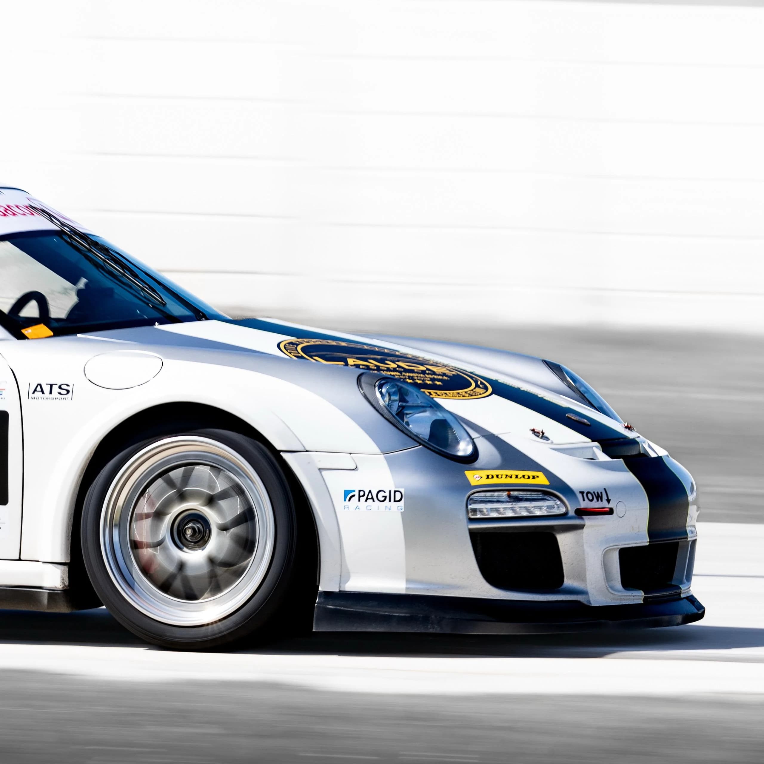 White Porsche 997 GT3 Cup car panning at speed on a racing circuit