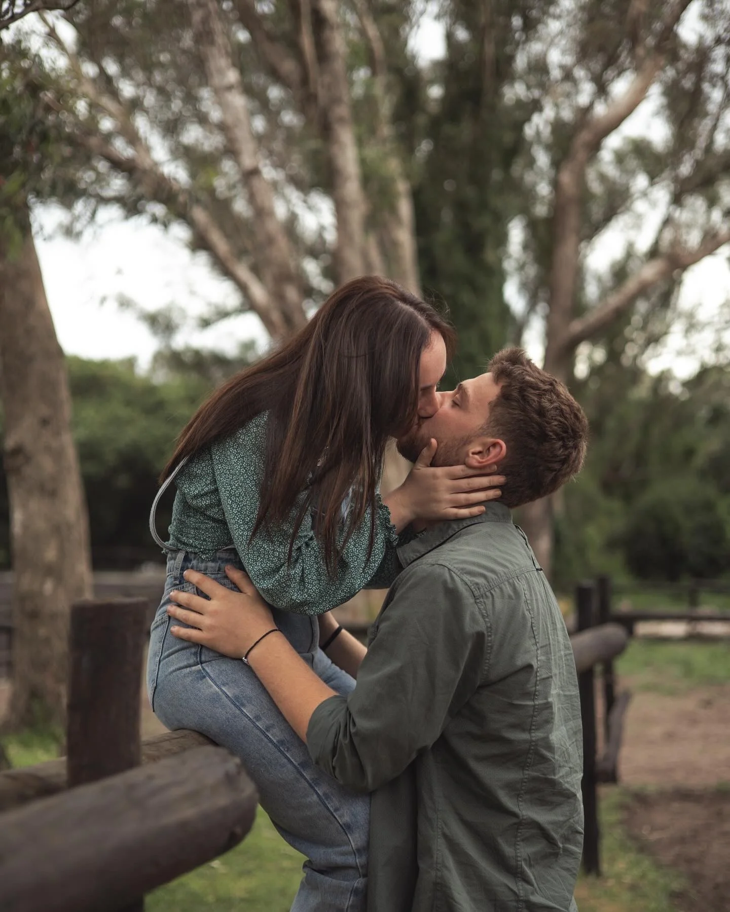 Couple kissing lifted up in park setting