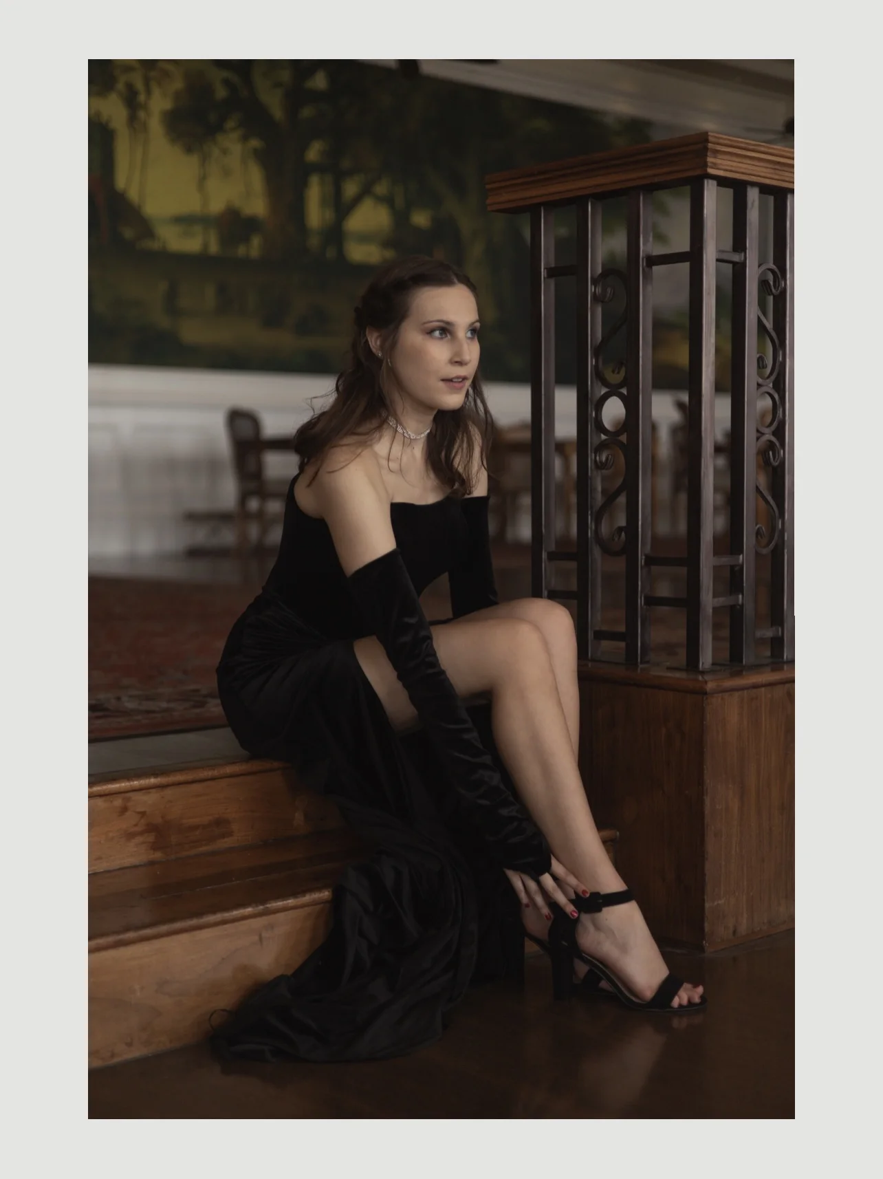 Woman seated on steps in black velvet gown